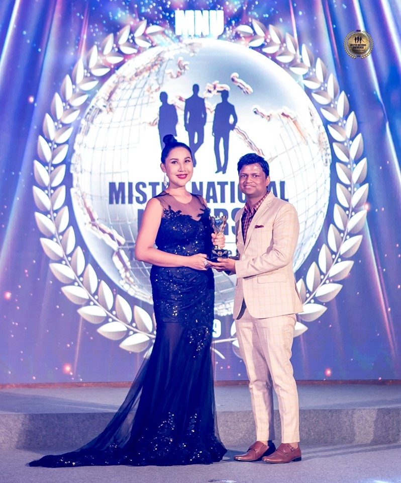 Sandeep Kumar receiving the Best Pageant Director award from the owner of Mister National Universe pageant, Tanya V in Thailand.